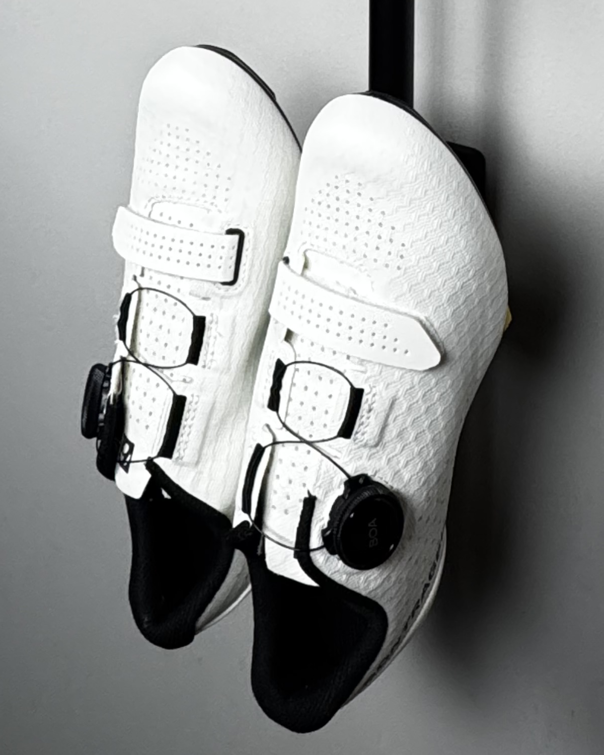 close up of cleat hanger assembled on wall, white cycling shoes on cleat hanger.