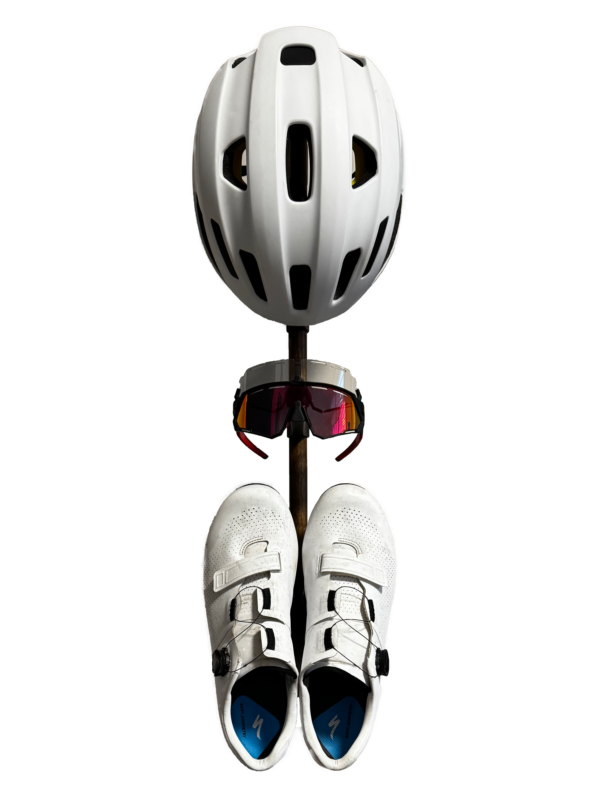 The Alta accessory rack with a white helmet, two cycling sunglasses, and white cycling shoes mounted, transparent (white) background. Front view.